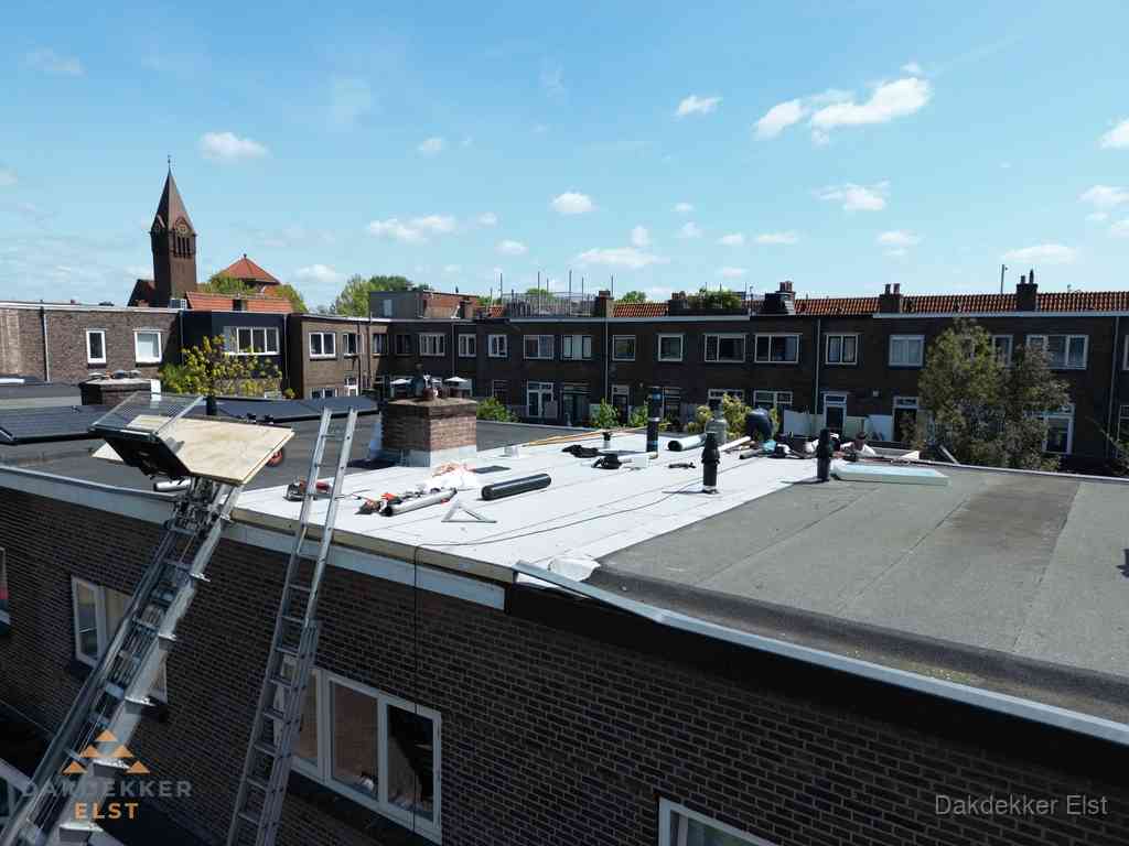Dakdekkers aan het werk op plat dak in Elst